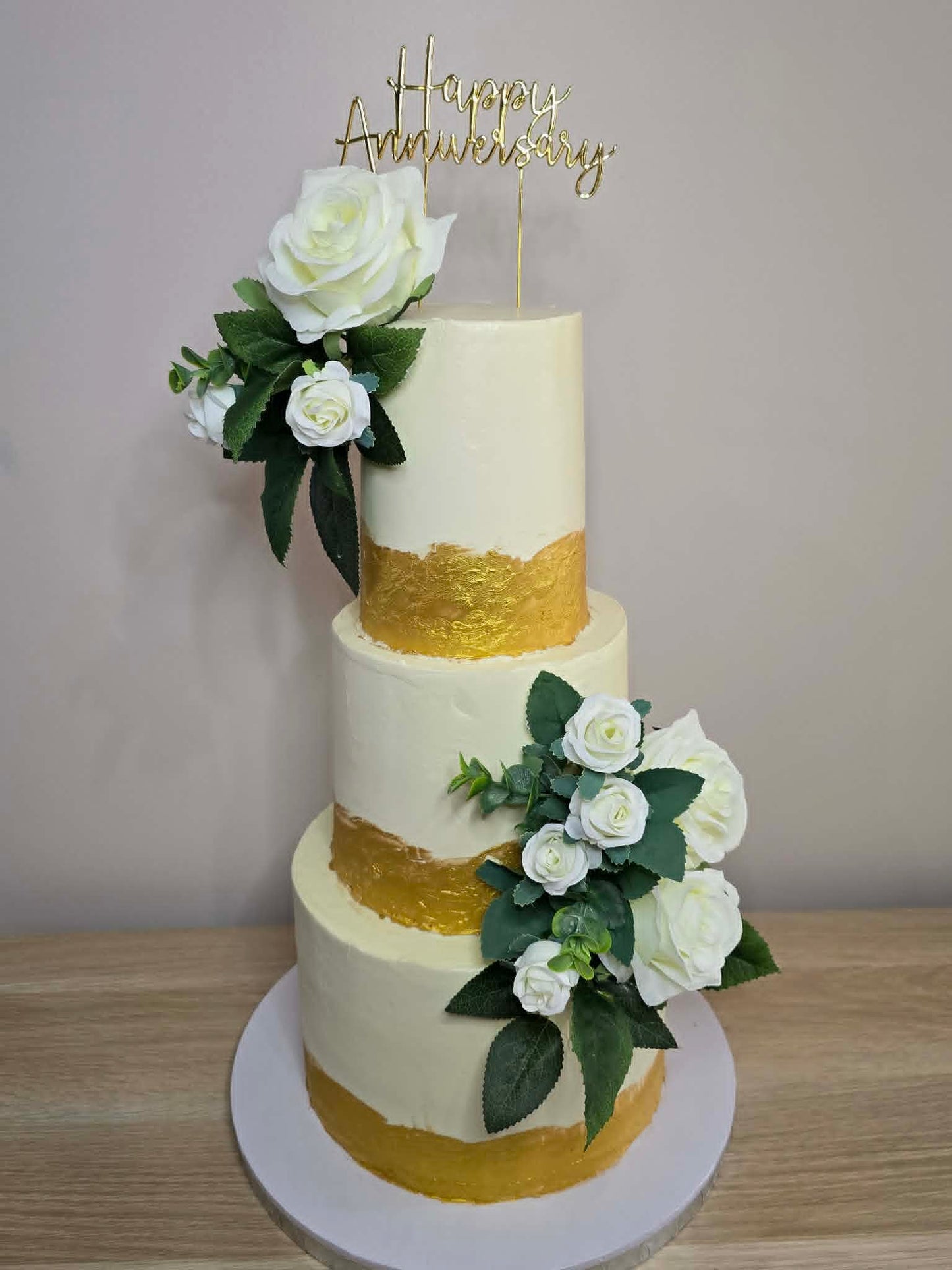 3 tier wedding cake with gold, and white flowers