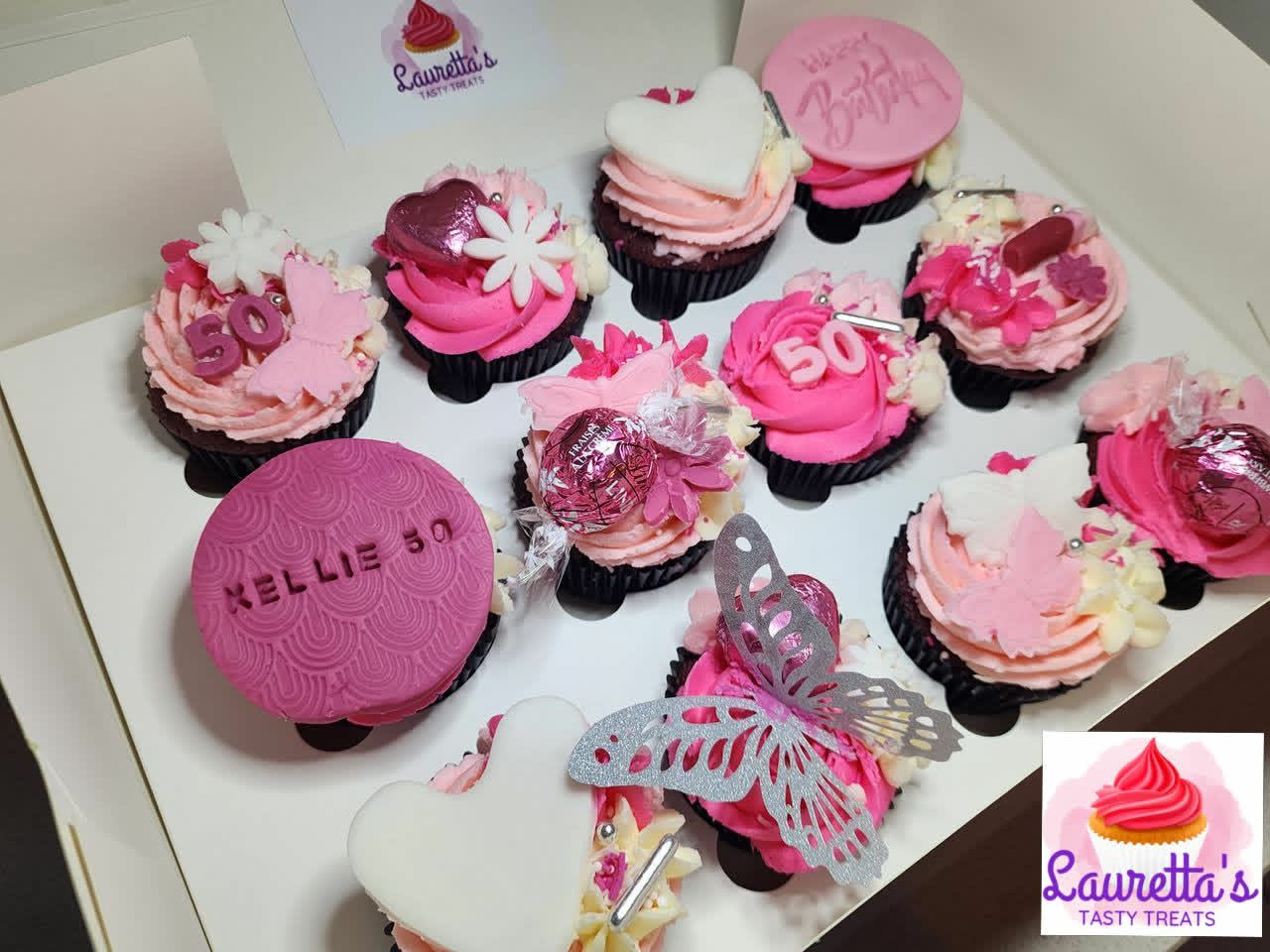 Decorative cupcakes with pink and white frosting, some with visible toppers.