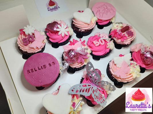 Decorative cupcakes with pink and white frosting, some with visible toppers.