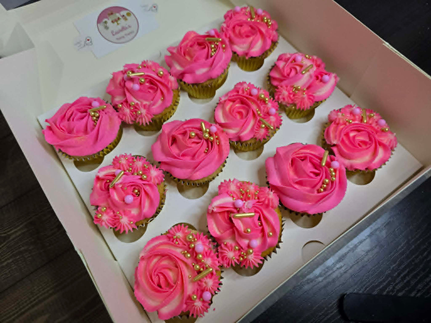 Box of cupcakes with pink frosting and gold accents 