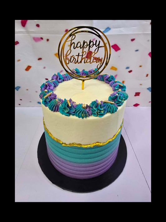 4 layer birthday cake with colourful frosting and 'Happy Birthday' topper on a white background.