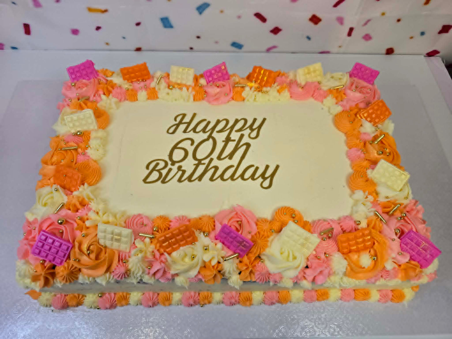 Birthday cake with colorful decorations and 'Happy 60th Birthday' text on a white background.