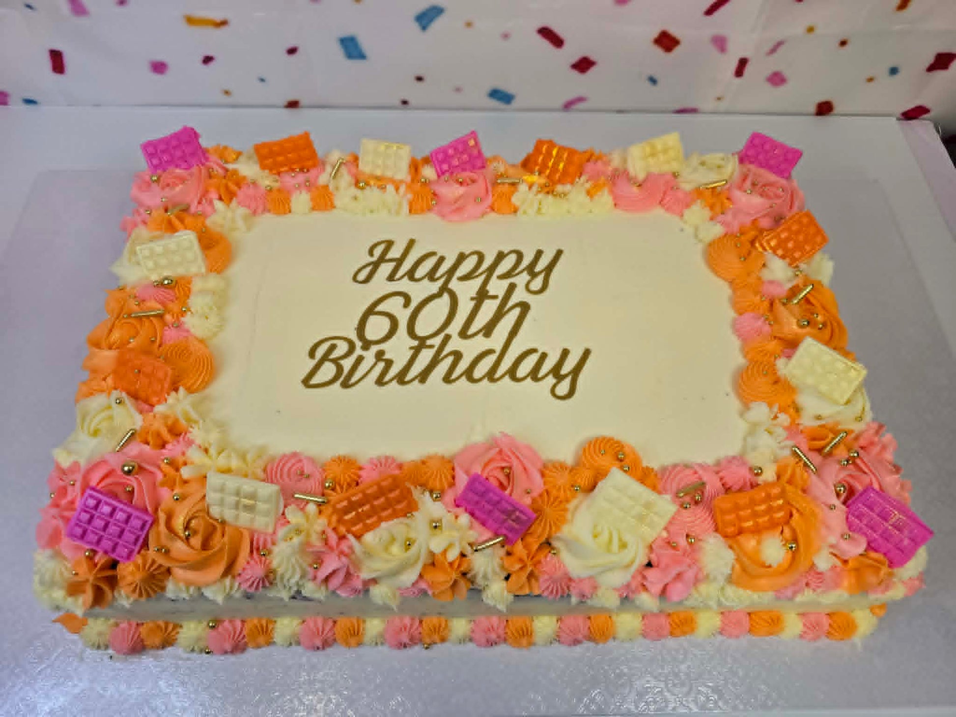 Birthday cake with colorful decorations and 'Happy 60th Birthday' text on a white background.